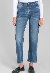 Jean droit en denim bleu avec un lavage clair, présentant une taille haute, une fermeture à deux boutons et des ourlets roulés.