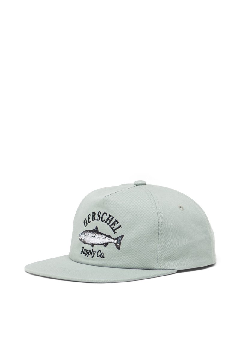 Cappello in cotone verde con visiera piatta, design di pesce ricamato e testo "HERSCHEL Supply Co." in nero, dotato di due fori di ventilazione sui lati.