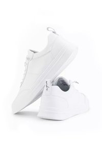 Sneakers bianchi con tomaia in pelle liscia, punta rotonda, chiusura con lacci e suola texturizzata. Presentano un tassello per il tallone e un logo discreto sul tallone.