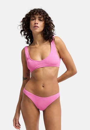 Ensemble bikini rose côtelé comprenant un haut à encolure dégagée et un bas taille basse, mettant en valeur un tissu texturé et un design minimaliste.