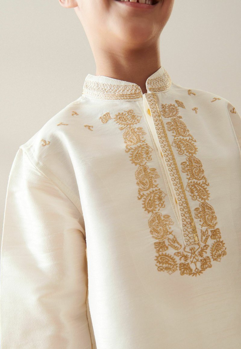 Helles Creme-Kurta mit aufwendiger goldener Stickerei entlang der Vorderseite und des Kragens, ausgestattet mit einem Stehkragen und einer Knopfleiste.