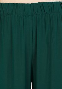 Teal wide-leg pants with an elastic waistband, made from lightweight, smooth fabric. Features soft pleats and no visible pockets.