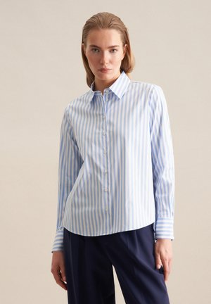 Camicia a righe blu chiaro e bianca con colletto, maniche lunghe e orlo arrotondato. Tessuto in cotone testurizzato con bottoni frontali.