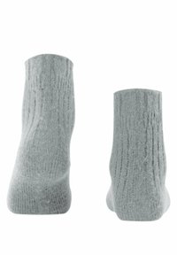 Calzini grigi a coste con una finitura testurizzata, d'altezza media e costruzione senza cuciture, mostrati da vedute laterali e posteriori.