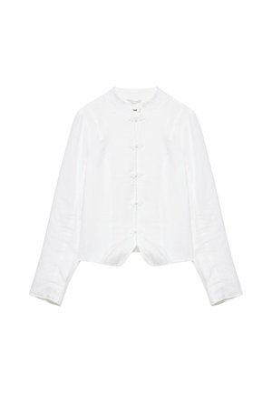 Blouse blanche à manches longues avec col mandarin et fermetures à boutons noués traditionnels sur le devant.
