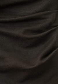 Tissu brun foncé texturé avec des plis doux et un motif tissé fin, montrant un drapé naturel et une ombre subtile.