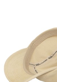 Cappello di corda beige con una texture morbida, visiera curvata e etichetta interna. Dettagli delle cuciture visibili sulla superficie esterna.