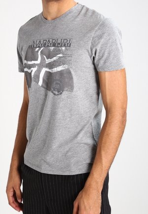 Grå T-shirt med korte ærmer, der har et sort grafisk design med tekst og mønstre på brystet. Lavet af blødt bomuldsstof.