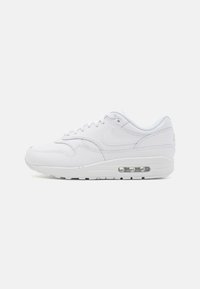 Biele tenisky Nike Air Max 1 s textúrovaným koženým zvrškom, šnurovaním a viditeľným vzduchovým tlmením v podrážke.