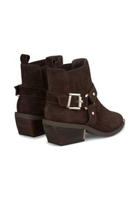Stivaletti alla caviglia in suede marrone con punta leggermente appuntita, tacco a blocco, cinturino decorativo con fibbia e dettagli cuciti lungo i lati.