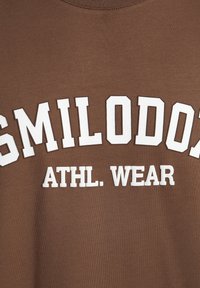 Sudadera marrón con letras en bloque blancas que dicen "SMILODON ATHL. WEAR." Presenta un cuello redondo clásico y una tela suave y texturizada.