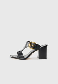 Sandali con tacco in pelle nera presentano una fascia ampia con una fibbia dorata e un tacco quadrato. Design open toe con una texture liscia.