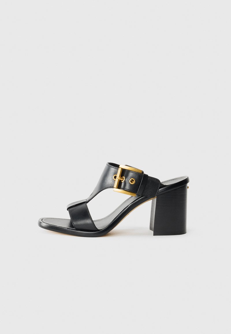 Sandali con tacco in pelle nera presentano una fascia ampia con una fibbia dorata e un tacco quadrato. Design open toe con una texture liscia.
