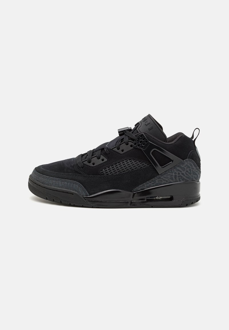 Black sneakers with a textured suede upper, mesh panels, and a patterned rubber sole. Features black laces and branding on the tongue.
