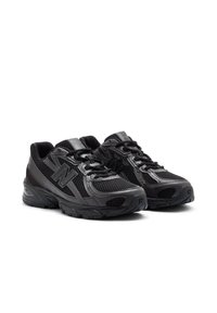 Black athletic shoes with a mesh upper, textured synthetic accents, and lace-up design. Features a cushioned sole for comfort and support.