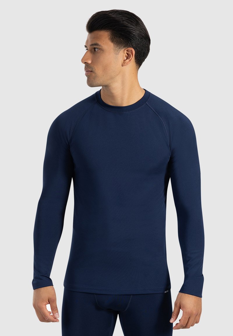 Maglietta atletica a maniche lunghe di colore blu navy con scollatura a girocollo, texture liscia e maniche raglan. Progettata per il massimo comfort durante le attività fisiche.