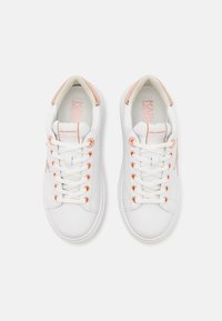 Baskets blanches avec une tige en cuir lisse, œillets en or rose et lacets. Présentent un accent rose clair sur le talon et une semelle intérieure signée.