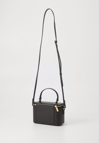 Black textured leather handbag with a boxy shape, gold hardware accents, a top handle, and a long adjustable shoulder strap.
