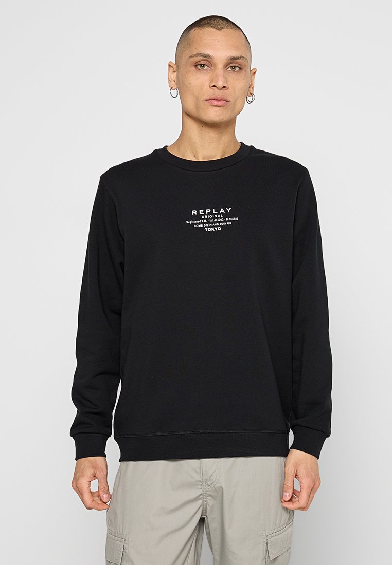 Zwart crewneck sweatshirt van zacht katoen, met een grafisch ontwerp aan de voorkant in witte tekst met "REPLAY" en een ontwerp element van Tokio.