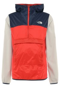 Veste légère avec capuche présentant un design bicolore rouge, marine et gris clair. Comprend une poche frontale et des poignets élastiques.