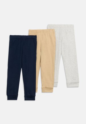 Drei Paar Kinder-Jogginghosen mit elastischem Bund in Marineblau, Beige und Hellgrau, nebeneinander flach auf einem weißen Hintergrund ausgelegt.