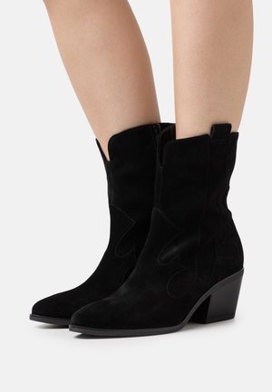Schwarze Wildleder-Ankle Boots mit spitz zulaufender Zehenpartie, dekorativen Nähten und einem 5 cm hohen Blockabsatz. Verfügt über ein ausgeschnittenes Oberteil und eine Zuglasche.