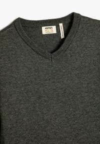 Ciemnoszary sweter z dekoltem w serek, z metką "Koton Kids 6-7 Y / 116-122 CM" oraz etykietą "Made in Turkey".