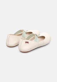 Cream leather ballerina flats with a rounded toe, elasticated mint green accents, and a brown rubber sole. Camper logo on the heel.