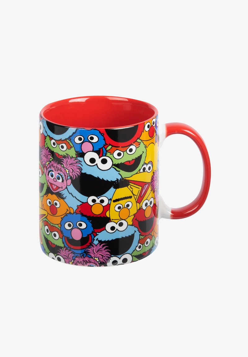 Ceramic mug with a red interior and handle, featuring colorful cartoon character faces on a black exterior. Round shape, glossy finish.