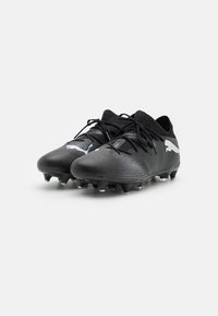 Scarpe da calcio nere con tomaia sintetica testurizzata, dotate di lacci neri, colletto in maglia e logo bianco sul lato. Suola con tacchetti.