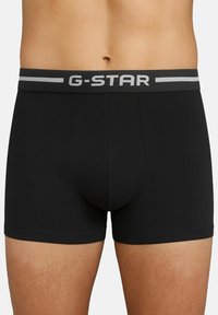Boxer-briefs noirs avec un élastique gris comportant le logo "G-STAR". Fabriqués en tissu lisse avec un design ajusté et des coutures plates.