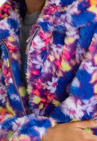 Kolorowa kurtka z futerka ekologicznego, łącząca odcienie fioletu, niebieskiego, różowego i zielonego, z zamkiem błyskawicznym i puszystą fakturą.