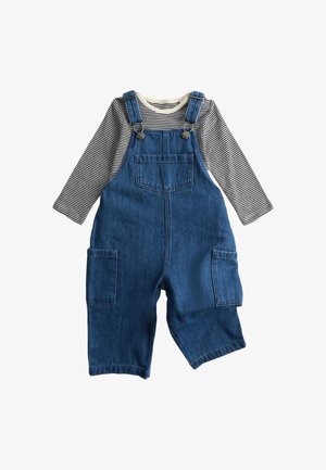 Denim-overalls med front- og sidelommer lagdelt over en langærmet sort-hvid stribet skjorte til et barn.