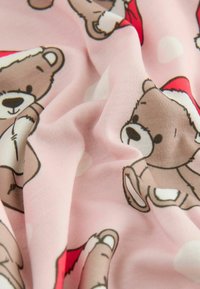 Pink fabric featuring a repeated pattern of teddy bears wearing red Santa hats, with soft texture and subtle white polka dots.