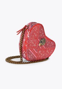 Czerwona torba w kształcie serca z teksturowanej tkaniny, metalowymi zdobieniami i złotym paskiem na ramię. Zawiera dekoracyjny akcent ptaka z przodu.