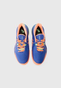 Blue athletic shoes with orange accents and laces, featuring a textured upper, smooth sole, and a cushioned black insole with logo.