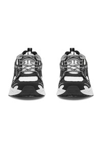 Zapatillas deportivas en blanco y negro con parte superior de malla, patrones texturizados, acentos reflectantes y una suela acolchada con un dibujo antideslizante.