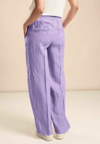 Světle levandulové, volné kalhoty s elastickým páskem a dvěma zadními kapsami, vyrobené z texturovaného lněného materiálu.