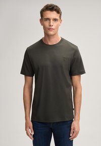 Dunkelgrünes T-Shirt mit kurzen Ärmeln aus Baumwollstoff, mit rundem Halsausschnitt und kleinem gesticktem Logo auf der Brust. Einfarbig, lässige Passform.