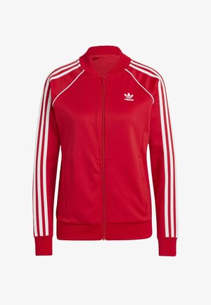 Czerwone kurtki zapinane na zamek, wykonane z gładkiego materiału, z białymi akcentami w formie trzech pasków na rękawach oraz małym białym logo na klatce piersiowej.