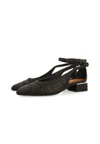 Ballerines en cuir tissé noir avec bout pointu, bride au poignet et petit talon carré. Présentent un motif texturé et des côtés ouverts.
