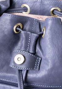 Leather bag in navy with gold-tone hardware. Features adjustable drawstring closure, matching stitching, and smooth texture.