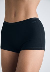 Boxers noirs sans coutures en tissu doux et extensible avec une finition lisse. Dispose d'une taille basse et d'un logo discret.
