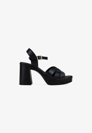Sandalia de plataforma de cuero negro con tacón alto grueso, puntera abierta, diseño de tira tejida y hebilla de tobillo ajustable.