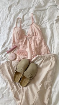 Svetloružový top s čipkovým okrajom, v kombinácii s béžovými pruhovanými nohavicami a šedými semišovými klobúkovými topánkami. Obsahuje ružový lesk na pery a hrebeň na bielom pozadí.