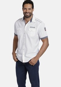 Weißes Kurzarmhemd mit Kragen, zwei Brusttaschen, grauen Akzenten und Knopfdetails, präsentiert von einem lächelnden männlichen Model.