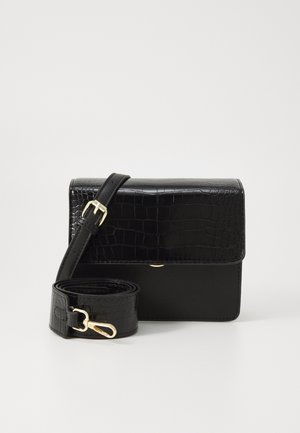 Zwarte rechthoekige crossbodytas met krokodillenprint klep en verstelbare band met gouden gesp en sluiting op een witte achtergrond.