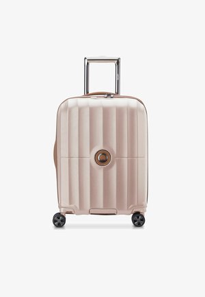Valigia rigida di colore rosa pallido con una finitura testurizzata, dotata di un logo circolare, manico estraibile e quattro ruote nere.
