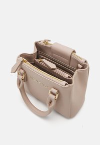 Kompakta, strukturēta rokas soma gaiši bežā sintētiskā materiālā ar zelta aksesuāriem. Satur divus rāvējslēdzēja nodalījumus un īsas rokturus.