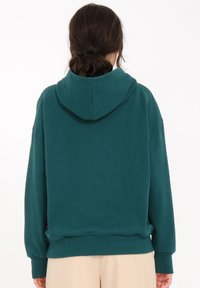 Teal hættetrøje med stor hætte, løs pasform, ribbede manchetter og kant, lavet af blødt stof. Minimalistisk design uden synlige logoer eller mønstre.